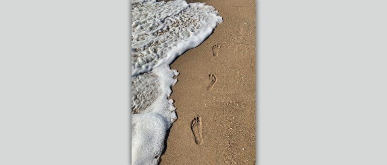 Spuren im Sand und Meeresschaum