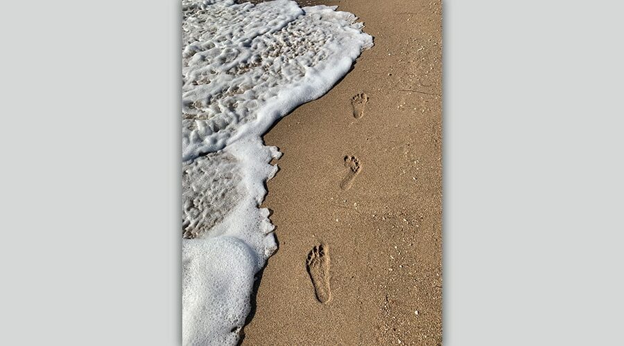 Spuren im Sand und Meeresschaum